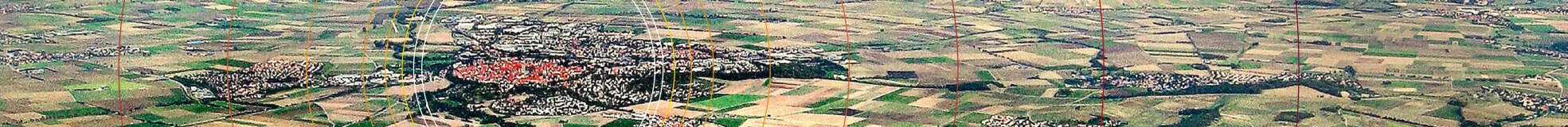 Das Becken des Rieskraters mit Siedlungen und Äcker grenzt sich gegen den bewaldeten Kraterrand ab. Im Zentrum von konzentrischen Kreisen liegt die runde Altstadt Nördlingen.